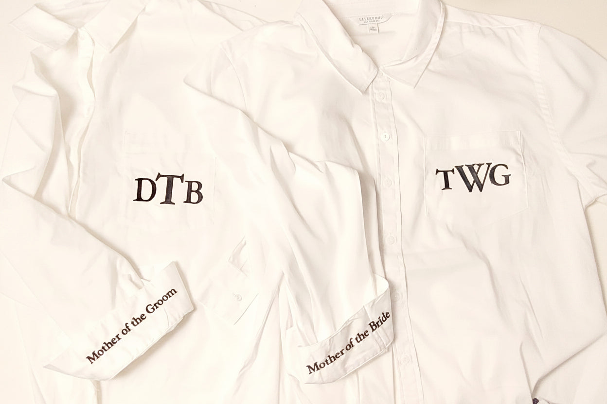 White shirts with embroidered text on a light background